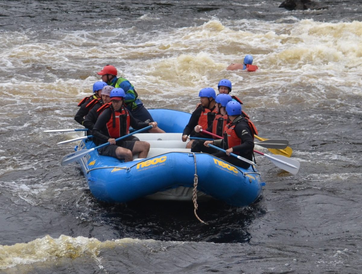 Image of a person floating down the river through the rapids behind the raft