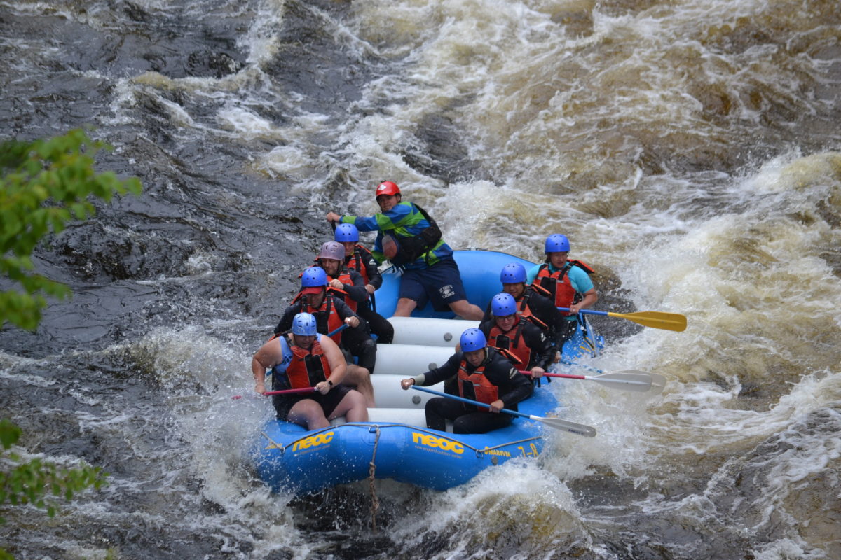 Image of 9 people on a raft entering a rapids